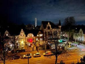 Una ciudad de noche con coches aparcados en una calle en Top Apartment Nähe Messe/DUS., en Krefeld