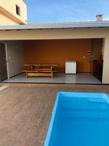 a patio with a bench and a table and a pool at CASA DE PRAIA in Prado