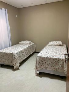 a room with two beds in a room at CASA DE PRAIA in Prado