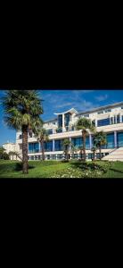 a large building with palm trees in front of it at SSP Suites- Cosy & Bel appartement 4 pièces 3 chambres 90M2 avec balcon in Épinay-sur-Seine