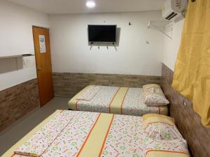 Zimmer mit 2 Betten und einem TV an der Wand in der Unterkunft Posada Cartagena Histórica in Cartagena de Indias