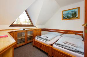 a attic bedroom with two beds and a window at Wellness Vila Astra in Stará Lesná