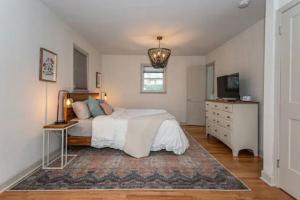 1 dormitorio con 1 cama, vestidor y TV en Pet Friendly House with Bike Trail Access and Huge Fenced Yard en Greenville
