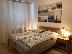 a bedroom with a bed with two lamps and a window at Spacious apartment in the park in Košice