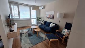 a living room with a blue couch and a table at Spacious apartment in the park in Košice