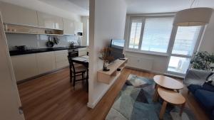 a kitchen and living room with a table and a couch at Spacious apartment in the park in Košice