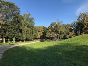 een park met een speeltuin op een grasheuvel bij Spacious apartment in the park in Košice