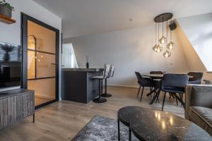 een woonkamer met een tafel en een eetkamer bij Luxe appartement in centrum van Groningen! in Groningen