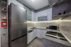 a kitchen with a stainless steel refrigerator and white cabinets at Apartment Monika in Kaštela
