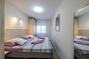 a bedroom with two beds and a mirror at Apartment Monika in Kaštela