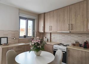 a kitchen with a table with a vase of flowers on it at Margarita Flat in Tripoli