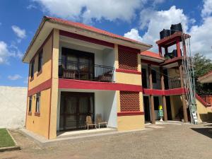 uma casa está a ser construída com uma escada em Missions Cafe Arua - GuestHouse em Arua