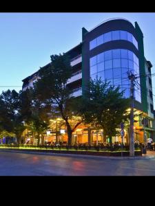 a large glass building with trees in front of it at M Central Park in Niš