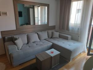a living room with a couch and a mirror at M Central Park in Niš