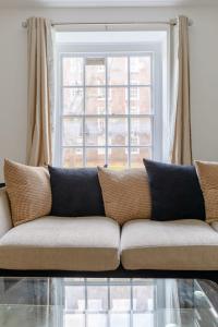 een bank in een woonkamer met een raam bij Inviting 2BD Flat 15 Minutes from Regents Park! in Londen