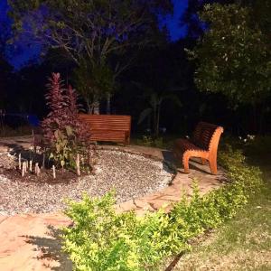 eine Holzbank, die nachts im Garten sitzt in der Unterkunft Villa Colombia in Vianí