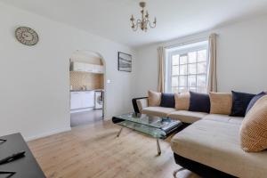 een woonkamer met een bank en een tafel bij Inviting 2BD Flat 15 Minutes from Regents Park! in Londen