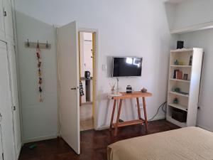 um quarto com uma mesa e uma televisão na parede em La casita de boedo em Buenos Aires