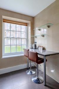 een keuken met een tafel en stoelen en een raam bij Inviting 2BD Flat 15 Minutes from Regents Park! in Londen