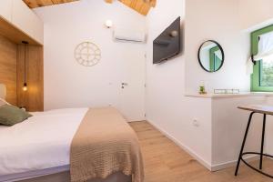 a bedroom with a bed and a sink and a mirror at Hidden House Porta in Krk +42 photos