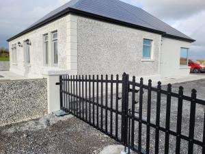 a black fence in front of a house at Maisie and Bea's cottage in Galway