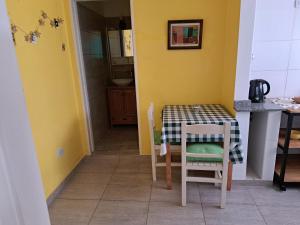 布宜諾斯艾利斯的住宿－La casita de boedo，厨房设有一张桌子和椅子,拥有黄色的墙壁
