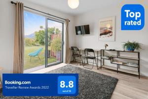 a living room with a sliding glass door at Wanaka Riverside 1 Bedroom Apartment in Wanaka