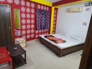 1 dormitorio con cama y pared roja en Hotel Nilay And Banquet (Vivaah Palace) en Kahalgaon