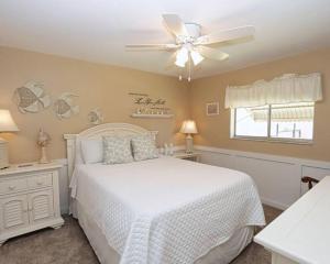 Un dormitorio con una cama blanca y un ventilador de techo. en Tropical Breeze Canal Waterfront Home, Heated Pool, en Cabo Coral 33 fotos más
