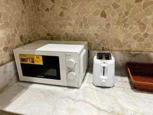 a microwave sitting on a counter next to a toaster at Brand new Modern Studio High Floor near Burj in Dubai