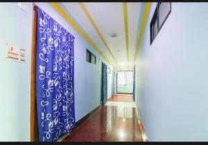 un corridoio in un edificio con pareti bianche e blu di Hotel Nilay And Banquet (Vivaah Palace) a Kahalgaon