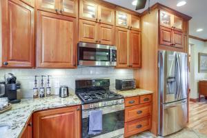 曼斯菲爾德的住宿－Warm and Cozy Mansfield Home Deck, Gas Fire Table!，厨房配有木制橱柜、炉灶和冰箱。