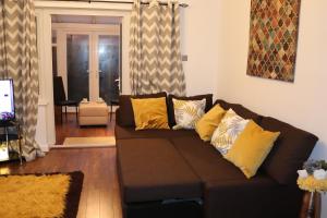 a living room with a brown couch with yellow pillows at Dove's Place in historic Rochester with Parking in Strood