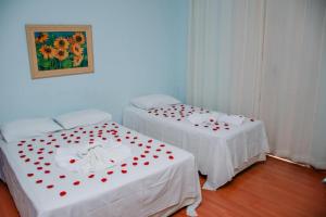 Dos camas con corazones rojos en una habitación en Pousada Arco-Íris en Lambari