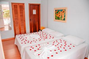 a bedroom with two beds with red hearts on them at Pousada Arco-Íris in Lambari