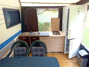 a kitchen in an rv with a sink and a table at Przyczepa kempingowa nad jez Gardno in Gardna Wielka
