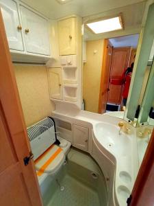 a small bathroom with a toilet and a sink at Przyczepa kempingowa nad jez Gardno in Gardna Wielka