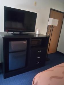 a black entertainment center with a flat screen tv on it at FairBridge Inn & Suites Sunnyside in Sunnyside