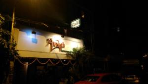 ein Schild an der Seite eines Gebäudes in der Nacht in der Unterkunft Hotel Sai Sanidhya in Thane