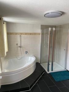 ein Badezimmer mit einer großen Badewanne und einer Dusche in der Unterkunft Schöne 2 Zimmer Ferienwohnung in Ebern in Ebern