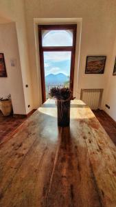 Habitación con una gran mesa de madera y una gran ventana. en Guest House Pedamentina, en Nápoles