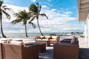 een terras met stoelen en palmbomen op het strand bij Banana River Resort in Cocoa Beach