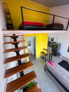 Zimmer mit einem Hochbett und einem Wohnzimmer in der Unterkunft apartaestudios las astromelias salento in Salento