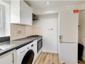 a kitchen with white cabinets and a stove top oven at flat 7 mornington crescent in London