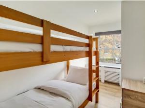 - une chambre avec 2 lits superposés et une fenêtre dans l'établissement flat 7 mornington crescent, à Londres