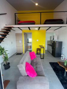 ein Wohnzimmer mit einem Sofa und rosa Kissen in der Unterkunft apartaestudios las astromelias salento in Salento