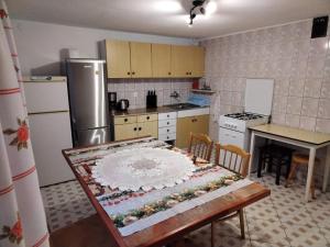 a kitchen with a table and a refrigerator and a table and chairs at Noclegi Beskidzkie in Korbielów