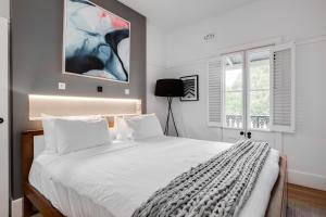 una camera da letto con un grande letto bianco con cuscini bianchi di Barangaroo Park Apartments by Urban Rest a Sydney