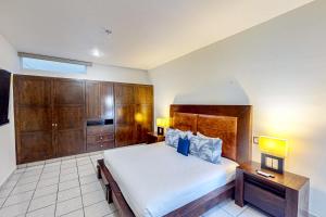 una camera con un grande letto e armadi in legno di Blue Bay #419 a Cabo San Lucas