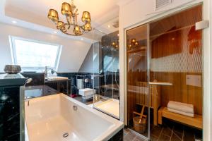 a bathroom with a large tub and a chandelier at La Belle 10 in Cologne